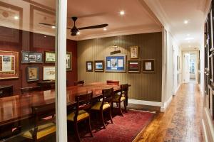 The Devon Valley Hotel في ستيلينبوش: غرفة طعام مع طاولة وكراسي خشبية كبيرة