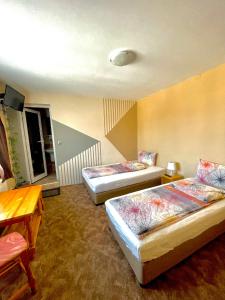 ドブリニシュテにあるAndreevi Guest Houseのベッド2台とテーブルが備わるホテルルームです。