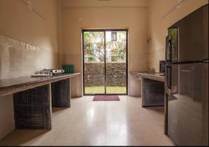 cocina grande con nevera y ventana grande en StayVista's Greenwoods Villa 7 - City-Center Villa with Private Pool, Terrace, Lift & Ping-Pong Table, en Lonavala 149 fotos más