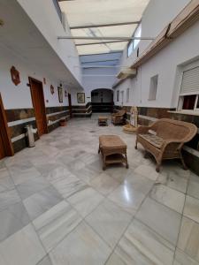 ヘレス・デ・ラ・フロンテーラにあるQuitagolpeのタイルフロアの広い客室で、テーブルと椅子が備わります。