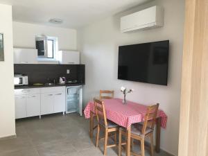 a kitchen with a table with chairs and a television at Podhájska - Holiday in Podhájska