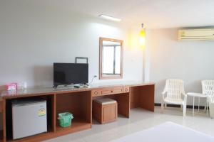 Habitación con escritorio, TV y espejo. en Sport Inn, en Chiang Rai