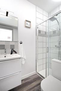 La salle de bains blanche est pourvue d'une douche et de toilettes. dans l'établissement Hyper Centre rue de la Roe, à Angers