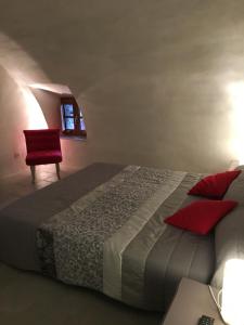 a bedroom with a large bed and a red chair at Casa Natalina de caractère entièrement rénovée classée 4 étoiles in Feliceto