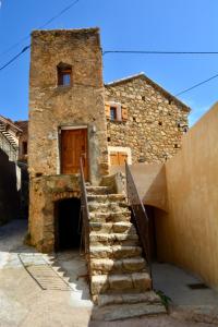 a stone building with stairs leading up to a door at Casa Natalina de caractère entièrement rénovée classée 4 étoiles in Feliceto