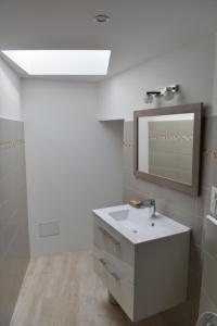 a bathroom with a sink and a mirror at Casa Natalina de caractère entièrement rénovée classée 4 étoiles in Feliceto