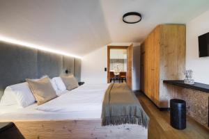 a bedroom with a large white bed with a wooden headboard at Thomanhof Chalet-Appartement in Saalfelden am Steinernen Meer