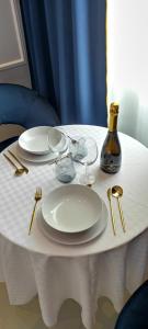 - une table blanche avec des assiettes, des verres et une bouteille dans l'établissement Boutique Studio, à Alghero 9 autres photos