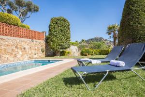 two lounge chairs sitting next to a swimming pool at 2MG - Blanes in Blanes