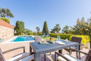 a patio with a table and chairs next to a swimming pool at 2MG - Blanes in Blanes
