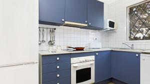 cocina con armarios azules y horno en MPinell 44, en L'Estartit