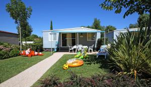 einen Garten mit einem Haus mit Spielsachen auf dem Rasen in der Unterkunft San Francesco Camping Village in Desenzano del Garda
