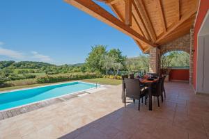 un patio con mesa y sillas junto a una piscina en Villa Marina con piscina by Wonderful Italy, en Soiano del Lago