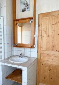 a bathroom with a sink and a mirror at Chambres d'Hôtes Le Bourdieu in Soulignac