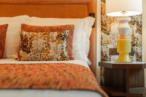 a bed with a pillow and a lamp on a table at Palácio Ludovice Wine Experience Hotel in Lisbon