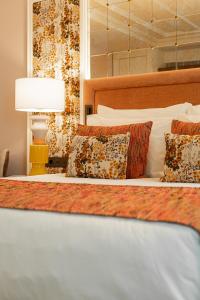 a bedroom with a bed with pillows and a lamp at Palácio Ludovice Wine Experience Hotel in Lisbon