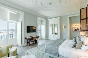 sypialnia z dużym łóżkiem i biurkiem w obiekcie Palácio Ludovice Wine Experience Hotel w Lizbonie