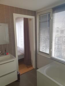 a bathroom with a sink and a tub and a window at Bed zonder Breakfast in Amsterdam