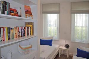 a living room with a couch and a book shelf at Villa Poseidon - WE 5 in Strandnähe und zentrumsnah in Binz