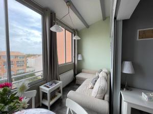 a small room with a couch and a window at Appartement Antinea in Cap d'Agde