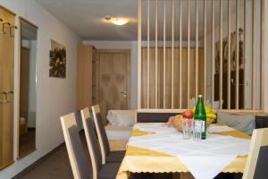 mesa de comedor con mantel y sillas blancas en Apart Haus Bernardes, en Fiss