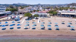 una vista aerea su una spiaggia con sedie e ombrelloni di cactus suites a Faliraki