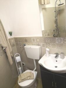 un bagno con un water bianco e un lavandino di CASA QUIDERA LOCAZIONE TURISTICA / AFFITTI BREVI a Castelvetrano Selinunte