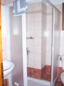 a shower in a bathroom with a toilet and a sink at Hotel Ilianna in Portariá