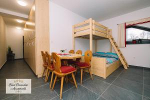 a room with a table and chairs and a bunk bed at Hostel Bled Paradise Slovenia in Bled-Rečica