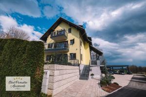 a yellow building with a sign in front of it at Hostel Bled Paradise Slovenia in Bled-Rečica