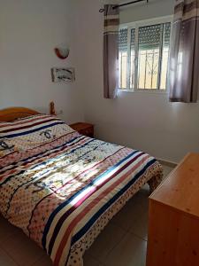 um quarto com uma cama com uma colcha colorida em Casa Joleen 2 em Villamartin