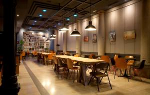 uma sala de jantar com mesas, cadeiras e luzes em Hostal Persal em Madrid