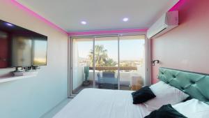 a bedroom with a bed and a large window at Village Naturiste Cap d'Agde, Studio Luxe Port Nature 7 in Cap d'Agde