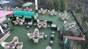 einen Blick über eine Terrasse mit Tischen und Stühlen in der Unterkunft Asia Health Resorts & Spa in Dharamshala