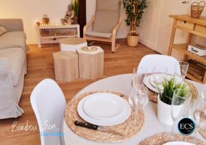 a living room with a table with white plates and glasses at "Bambou Zen" - 5 couchages - Vieux Tours in Tours