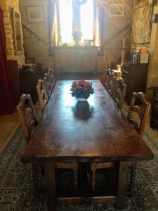 a wooden table with a vase of flowers on it at Gîte du ru d ausson in Avrigny +15 photos