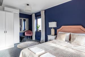 1 dormitorio con 1 cama con pared azul en Przystań Stegna, en Stegna