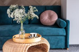 a table with a vase of flowers and a cup of coffee at Przystań Stegna in Stegna