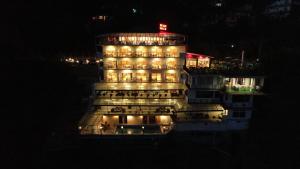 a building with lights on top of it at night at Asia Health Resorts & Spa in Dharamshala