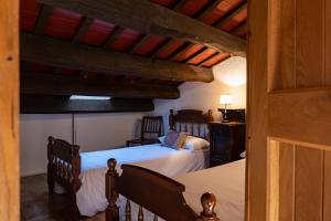 a bedroom with two beds in a room with a ceiling at Can Barrina in Montseny