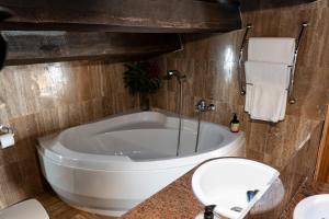 a bathroom with a tub and a toilet and a sink at Can Barrina in Montseny