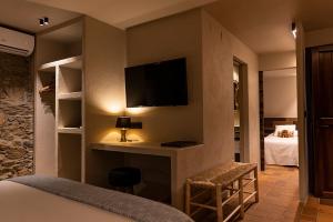 a hotel room with a bed and a tv on the wall at Can Barrina in Montseny