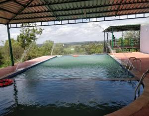 ein großer Pool mit Wasser in einem Haus in der Unterkunft StayApart - Deccan Trails Vikarabad in Vikārābād