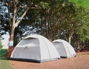 two tents sitting on the ground next to trees at StayApart - Deccan Trails Vikarabad in Vikārābād