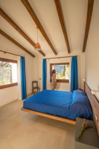 um quarto com uma grande cama azul com cortinas azuis em Villa Corbezzolo (Country House) em Dorgali