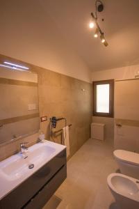 uma casa de banho com um lavatório, um WC e um espelho. em Villa Corbezzolo (Country House) em Dorgali