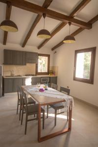 comedor con mesa y sillas en la cocina en Villa Corbezzolo (Country House), en Dorgali