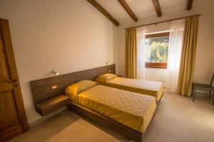 um quarto com 2 camas e uma janela em Villa Corbezzolo (Country House) em Dorgali