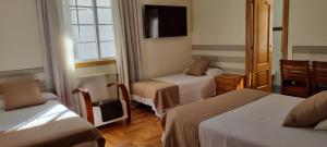 a hotel room with two beds and a tv at Hotel Miramar Playa America Nigran in Nigrán