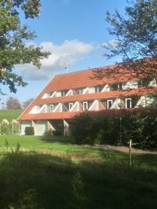 a large wooden building with a red roof at De Tureluur Bruinisse in Bruinisse